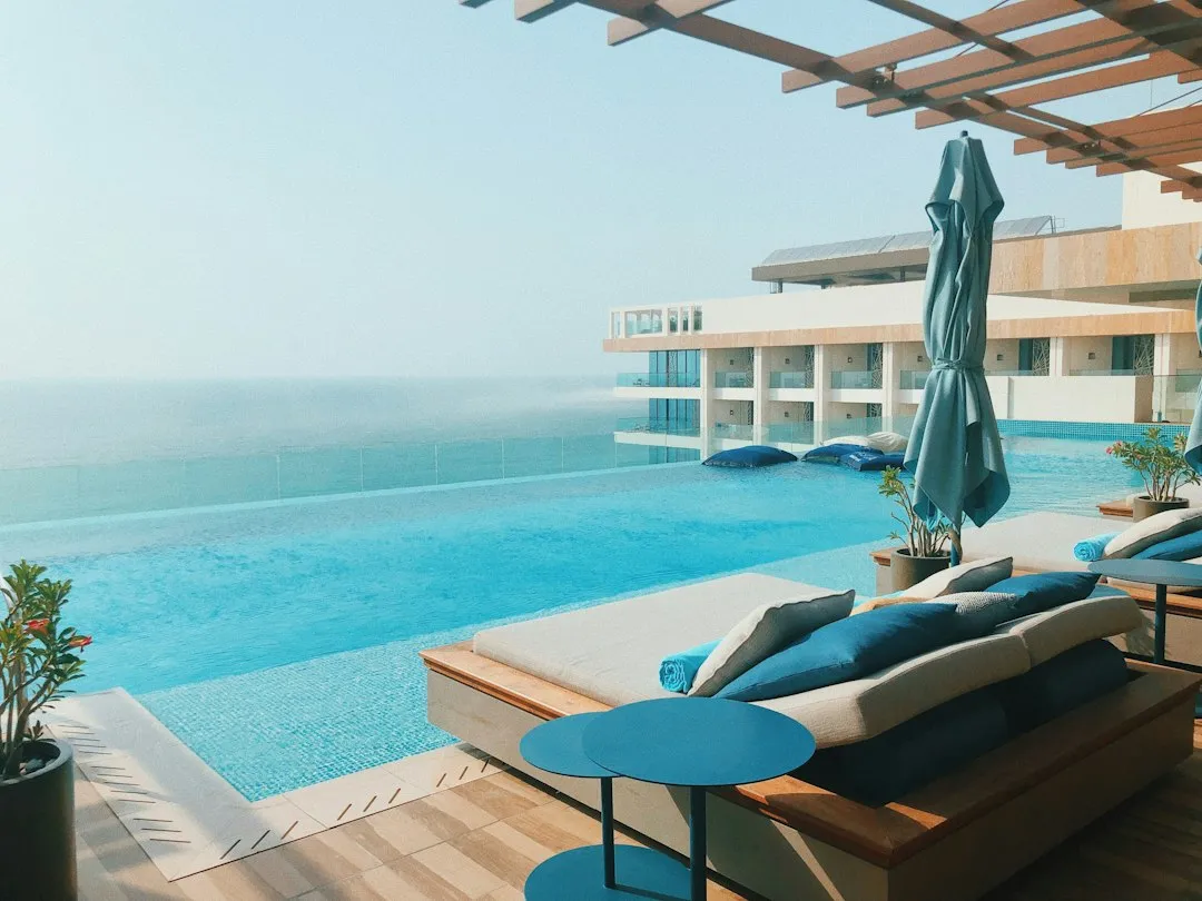 Sun loungers beside a sunlit hotel pool